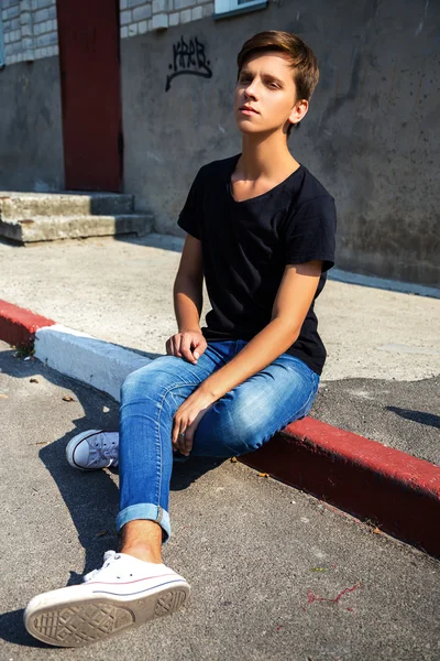 Un joven sentado al aire libre. retrato de moda . —  Fotos de Stock