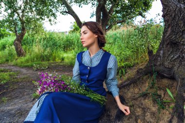 Açık alan mavi elbiseli güzel esmer bir kadın portresi