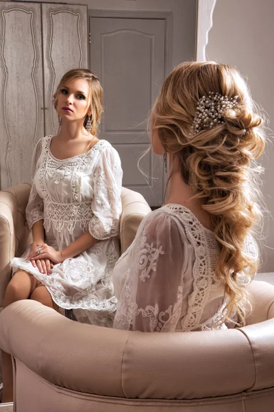 金发新娘穿着白色礼服坐在镜子里 — 图库照片