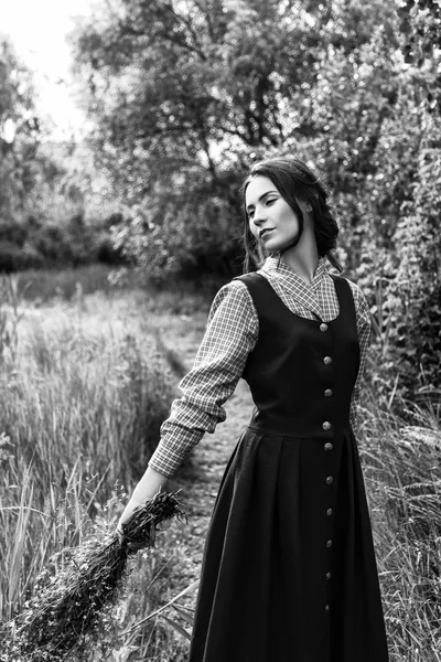 Outdoor Portret van een mooie brunette vrouw in blauwe jurk in het veld. Zwart-wit foto — Stockfoto