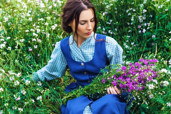 Outdoor Portret van een mooie brunette vrouw in blauwe jurk in het veld — Stockfoto