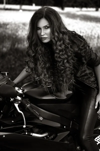 Sexual biker woman wearing black leather jacket with her sport m — Stock Photo, Image