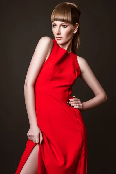 Schöne Frau Modell posiert in einfachen eleganten roten Kleid im Studio auf weißem Hintergrund — Stockfoto