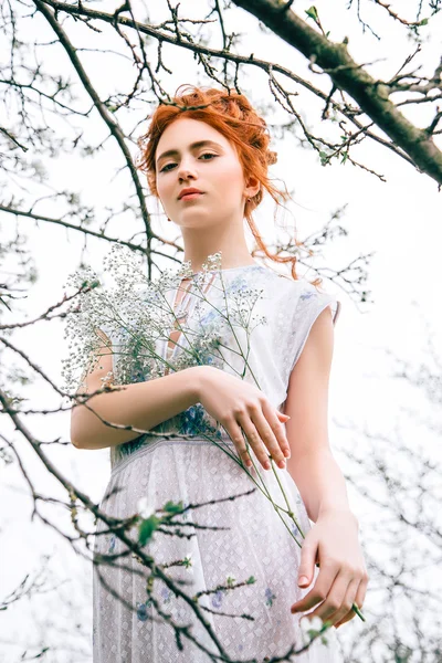 Portret van een mooi roodharig meisje in de lentetuin — Stockfoto