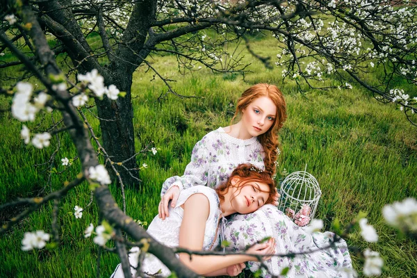 Portret van twee prachtige roodharige meisjes in de lentetuin — Stockfoto