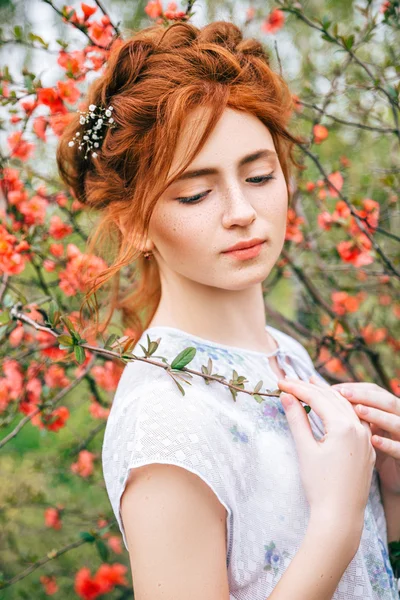 Portret van een mooi roodharig meisje in de lentetuin — Stockfoto