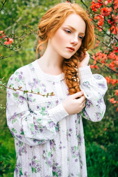 Portret van een mooi roodharig meisje in de lentetuin — Stockfoto