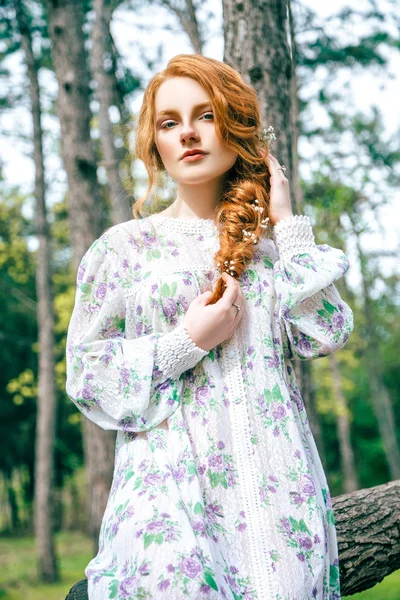 Portret van een mooi roodharig meisje in de lentetuin — Stockfoto