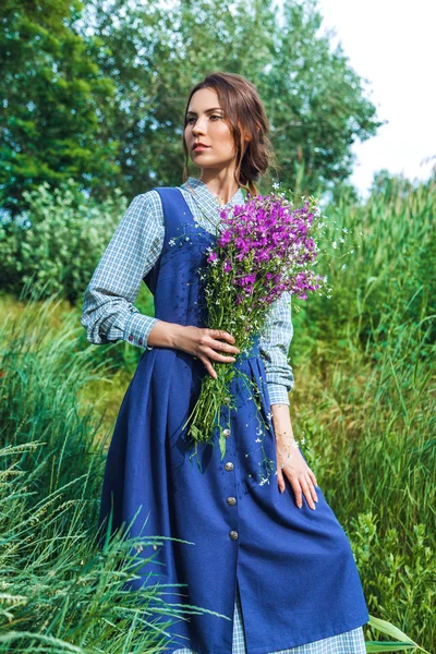 Outdoor Portret van een mooie brunette vrouw in blauwe jurk in het veld — Stockfoto