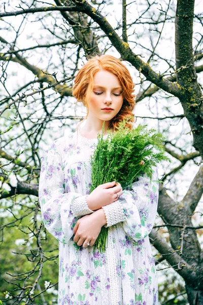 Portret van een mooi roodharig meisje in de lentetuin — Stockfoto