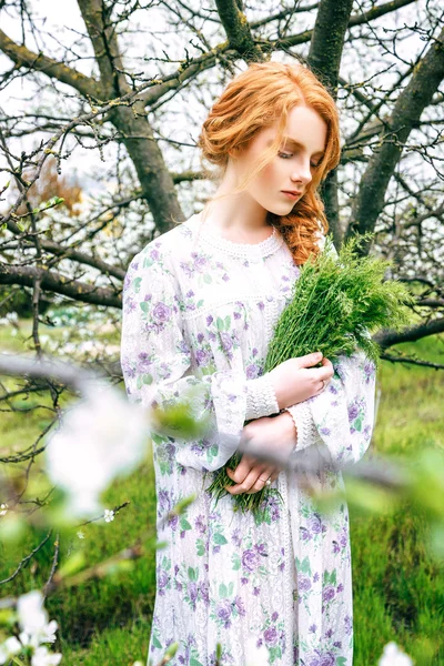 Portret van een mooi roodharig meisje in de lentetuin — Stockfoto