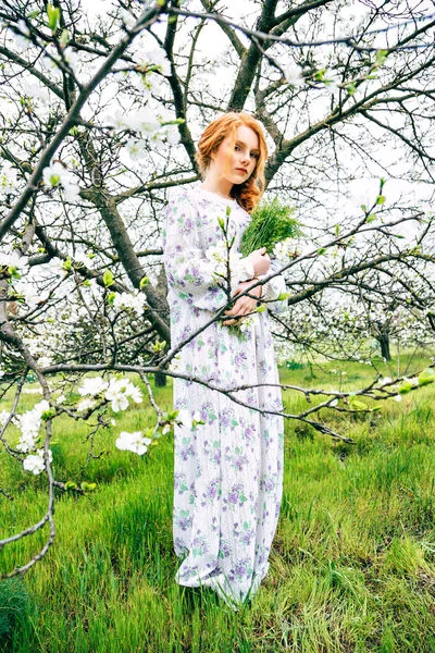 Portret van een mooi roodharig meisje in de lentetuin — Stockfoto