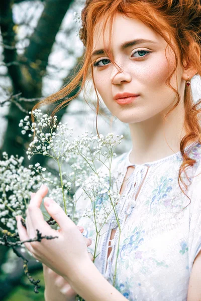 Portret van een mooi roodharig meisje in de lentetuin — Stockfoto