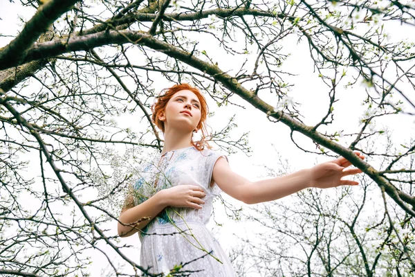 Portret van een mooi roodharig meisje in de lentetuin — Stockfoto