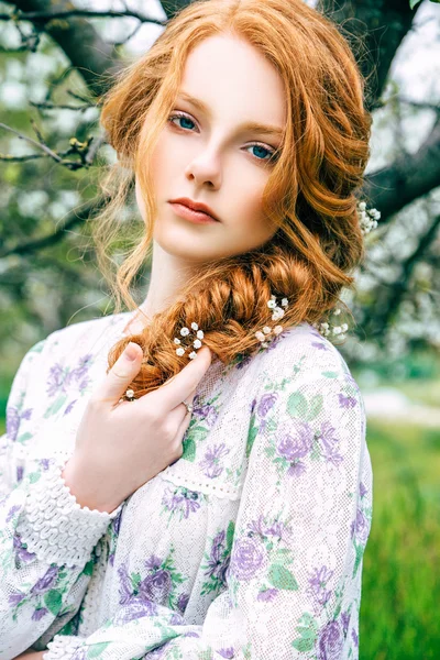 Portret van een mooi roodharig meisje in de lentetuin — Stockfoto