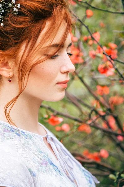 Retrato de uma linda menina ruiva no jardim da primavera — Fotografia de Stock