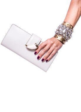 Beyaz arka planda beyaz deri bir debriyaj tutan kadının eli izole.