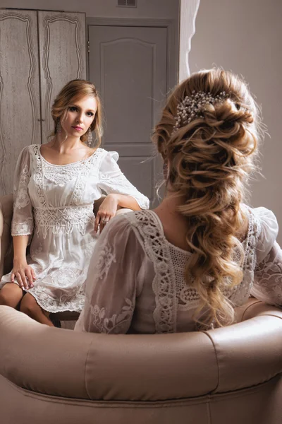 De blonde Haid bruid zitten in witte jurk netjes de spiegel — Stockfoto