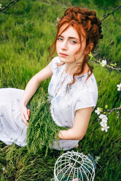 Portret van een mooi roodharig meisje in de lentetuin — Stockfoto