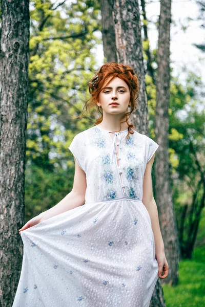 Portret van een mooi roodharig meisje in de lentetuin — Stockfoto