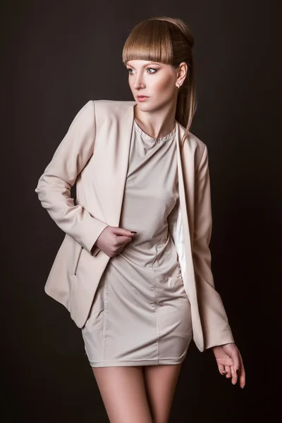 Schöne Frau Modell posiert in einfachen eleganten in einem leichten Anzug im Studio auf schwarzem Hintergrund — Stockfoto