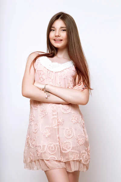 A beautiful 13-years old girl dressed in pink dress in studio on white background — Stock Photo, Image