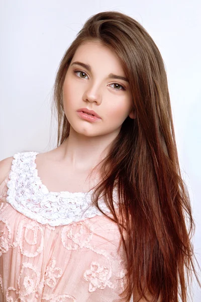 Une belle fille de 13 ans vêtue de robe rose en studio sur fond blanc — Photo