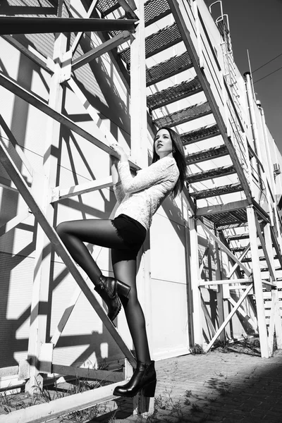 Black and white street photography. Young beautiful brunette girl posing in city.