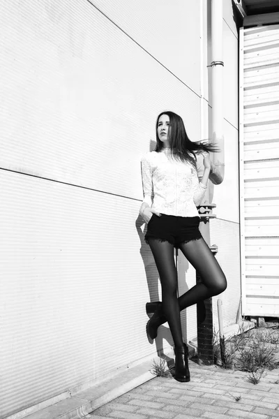 白黒のストリートフォトグラフィー。街でポーズ若い美しいブルネットの女の子. — ストック写真