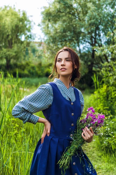 Outdoor Portret van een mooie brunette vrouw in blauwe jurk in het veld — Stockfoto