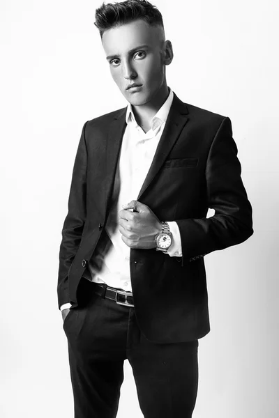 Fashion young businessman black suit casual poses at studio. Black and white — Stock Photo, Image