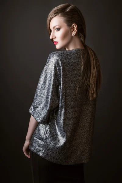 Modemädchen posiert in der silbernen Jacke. Studiofoto. schwarzer Hintergrund — Stockfoto