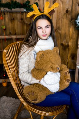 ayı odada ahşap duvarlar ile oturuyor ve onun elinde kızla