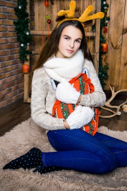 ahşap duvarları olan bir oda güzel bir kız oturuyor. Yeni yıl ve Chris