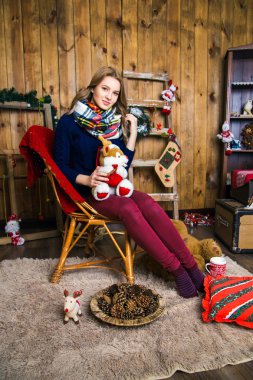 kız ile ahşap duvar odadaki oturma onun elinde bir oyuncakla