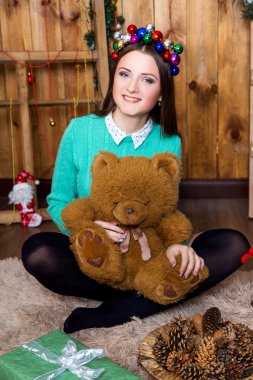 ayı odada ahşap duvarlar ile oturuyor ve onun elinde kızla