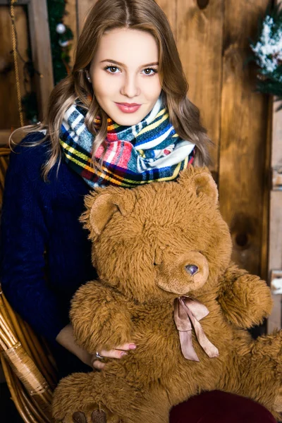 Dziewczyna z niedźwiedzia w ręku, siedząc w pokoju z drewnianymi ścianami — Zdjęcie stockowe