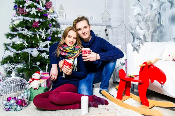 falling in love  boy and  girl sitting near the Christmas tree i