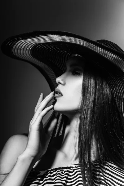 Fashion girl in a big hat in the studio. Black and white — Stockfoto