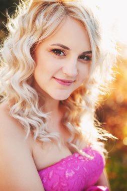 Doğada gülümseyen genç bir kızın portresi