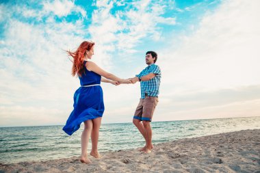  a young couple enjoys a mid summer late afternoon, on a wet san
