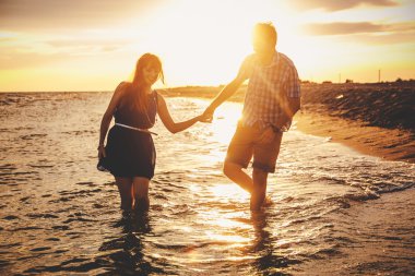  a young couple enjoys a mid summer late afternoon, on a wet san