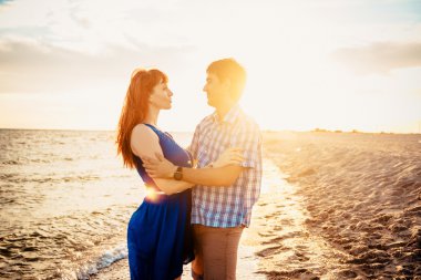  a young couple enjoys a mid summer late afternoon, on a wet san