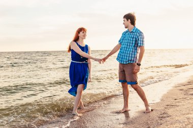  a young couple enjoys a mid summer late afternoon, on a wet san