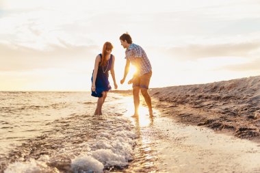  a young couple enjoys a mid summer late afternoon, on a wet san
