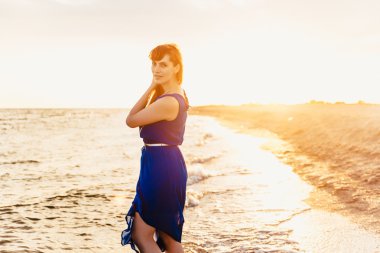 Sahilde yürüyen bir kadın.