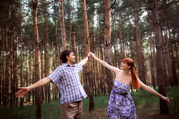 Una joven pareja enamorada caminando por el bosque —  Fotos de Stock