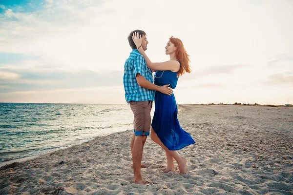 Un jeune couple profite d'un milieu d'été en fin d'après-midi, sur un san humide — Photo