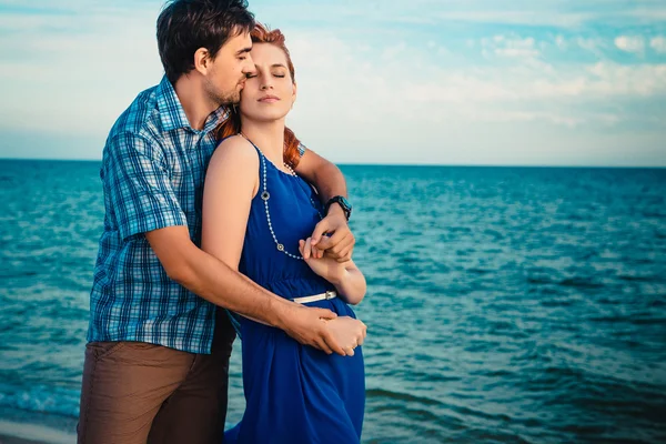 Una giovane coppia gode di una metà estate nel tardo pomeriggio, su un bagnato san — Foto Stock