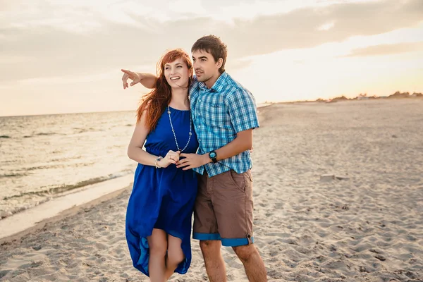 A young couple enjoys a mid summer late afternoon, on a wet san — Stock Fotó